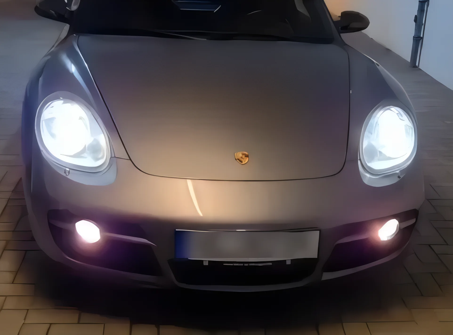 Porsche Cayman S cinzento com os faróis acesos